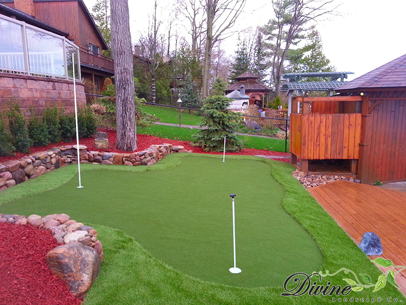 Artificial putting green and river rock retaining wall